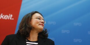 Andrea Nahles in schwarzem Kostüm lächelt und guckt nach rechts oben