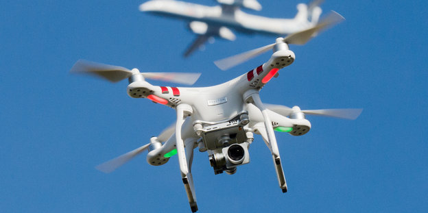 Zwei Drohnen fliegen vor blauem Himmel