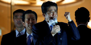 Shinzo Abe spricht in ein Mikro und macht die linke Hand zur Faust