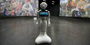Ein Roboter vor einer Wand mit Bildern