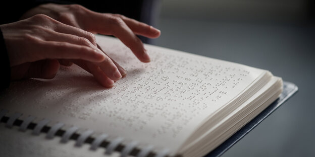 Eine Hand ließt Brailleschrift Eine Hand ließt Brailleschrift