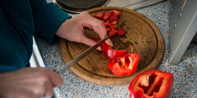 Paprika wird auf einem Holzbrett geschnitten