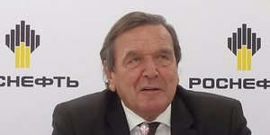 Gerhard Schröder sitzt vor einer Wand voller Rosneft-Logos