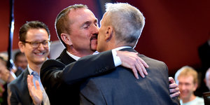 Zwei Männer küssen und umarmen sich