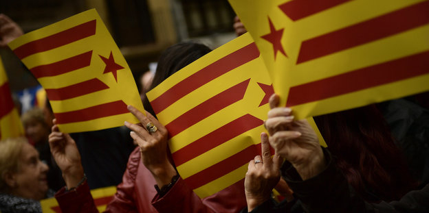 Hände halten die Flagge Kataloniens