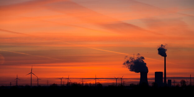 Die aufgehende Sonne taucht den Himmel hinter dem Kohlekraftwerk Mehrum in Hohenhameln in warmes Licht