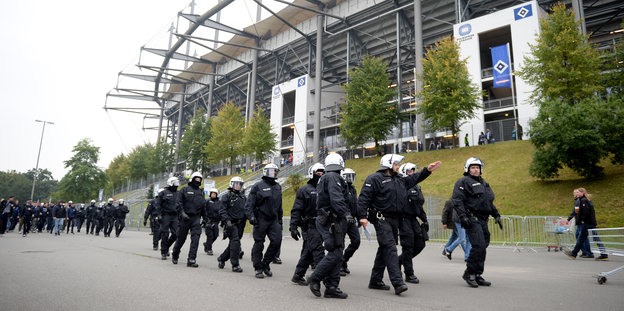 eine gruppe Polizisten geht vor dem Volksparkstadion in Hamburch