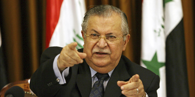 Dschalal Talabani zeigt mit beiden Zeigefingern nach vorne