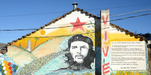 Eine Hauswand mit dem gemalten Portrait von Che Guevara