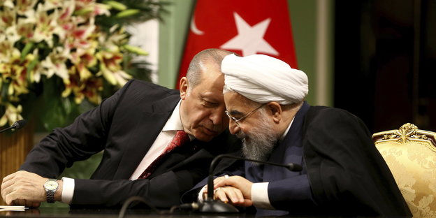 Erdogan (l.) und Hassan Ruhani tuscheln während einer Pressekonferenz am 04.10.2017 in Teheran