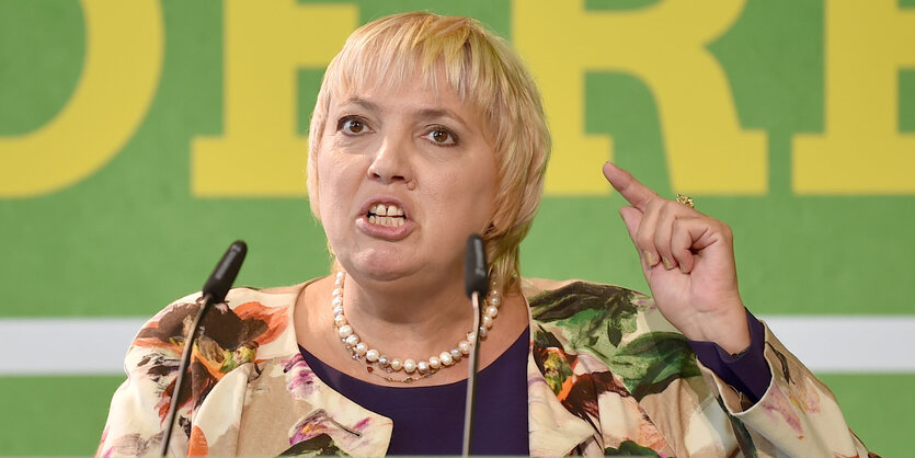 Claudia Roth gestikuliert hinter einem Mikrofon