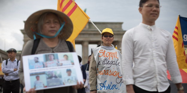 Exil-Vietnamesen mit Flaggen, Hüten und Banner vor dem Brandenburger Tor in Berlin