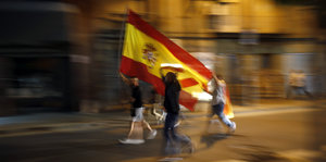 Demonstranten schwenken die spanische Flagge