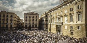 Ein Platz in Barcelona ist voller Menschen, die komplett weiß gekleidet sind