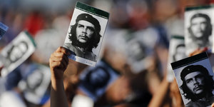 Jemand hält in einer Menschenmenge ein Bild von Che Guevara hoch