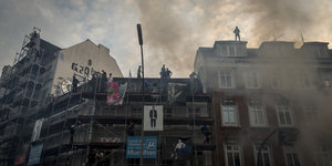 G20-Demonstranten stehen auf Hausdach
