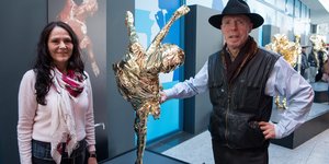Anatom Gunther von Hagens und seine Frau Angelina Whalley stehen neben einem verdeckten Ausstellungsstück