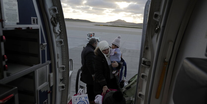 Eine Familie mit Kindern besteigt einen Flieger