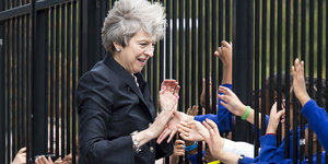 Theresa May schüttelt in einer Schule die Hände von Schülern
