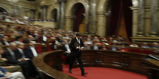 Carles Puigdemont läuft über einen roten Teppich im Parlament in Barcelona