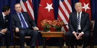 Erdoğan und Trump sitzen vor Flaggen