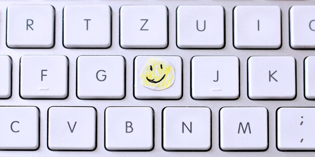 Ein Smiley klebt auf einer Tastatur