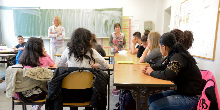 Kinder an Tischen im Klassenraum