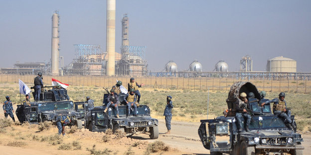 Militärfahrzeuge vor einem Ölfeld