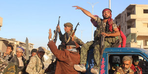 Kurdische Kämpfer in Siegerpose auf einem Truck