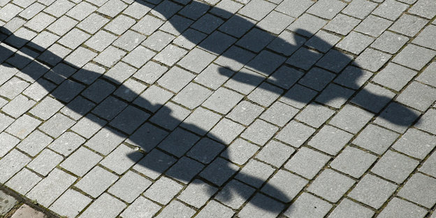 Schatten von zwei Menschen auf dem Straßenpflaster
