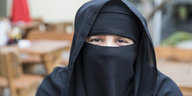Burka tragende Frau guckt in die Kamera