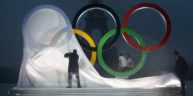 Menschen enthüllen die Olympischen Ringe