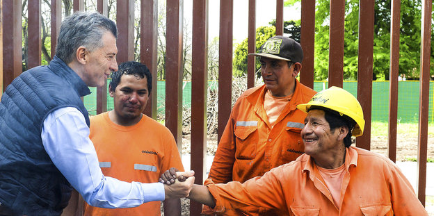 Mauricio Macri schüttelt dem einem Arbeiter die Hand