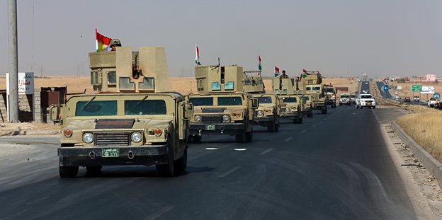 Militärfahrzeuge fahren in einer Reihe auf einer Straße