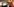 ein Mann mit erhobener rechter Hand, im Hintergrund eine chinesische Fahne