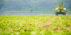 Ein Landwirt versprüht Herbizide auf einem Feld