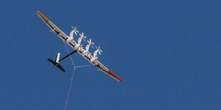 Ein Flugzeug mit Windräder wird von einer Leine gehalten