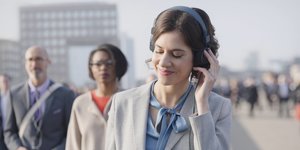 Eine Frau mit Blazer trägt große Kopfhörer