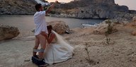 Der Bräutigam hat die Hosen runtergelassen, seine Braut kniet vor ihm und simuliert einen Blow Job, vor der malerischen Kulisse von Lindos auf Rhodos