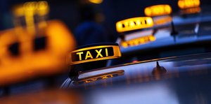 Mehrere leuchtende Taxischilder hintereinander