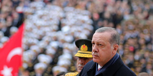 Mann neben Kranz mit der türkischen Fahne