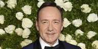 Mann vor einer Blumenwiese, es ist der Schauspieler Kevin Spacey