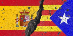Eine spanische und eine katalanische Flagge werden durch einen Riss geteilt