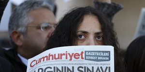 Frau hält eine Zeitung mit der Aufschrift "Cumhüriyet" hoch