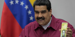 Venezuelas Präsident zeigt lachend einen Geldschein