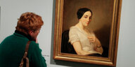 Eine Frau steht vor einem Gemälde