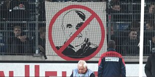 an einem Zaun im Stadion hängt ein Verbotsschild mit dem Konterfei Martin Kinds