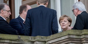auf einem Balkon stehen vier Männer und Angela Merkel