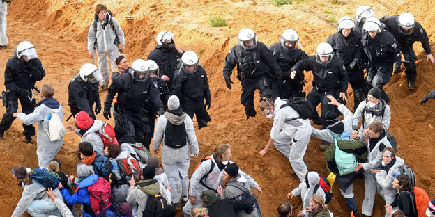 Demonstranten und Polizisten stehen sich im Tagebau Hambach gegenüber