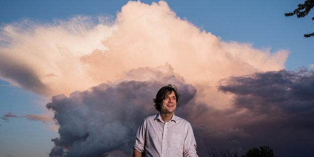Künstler John Maus steht vor einer großen Wolke